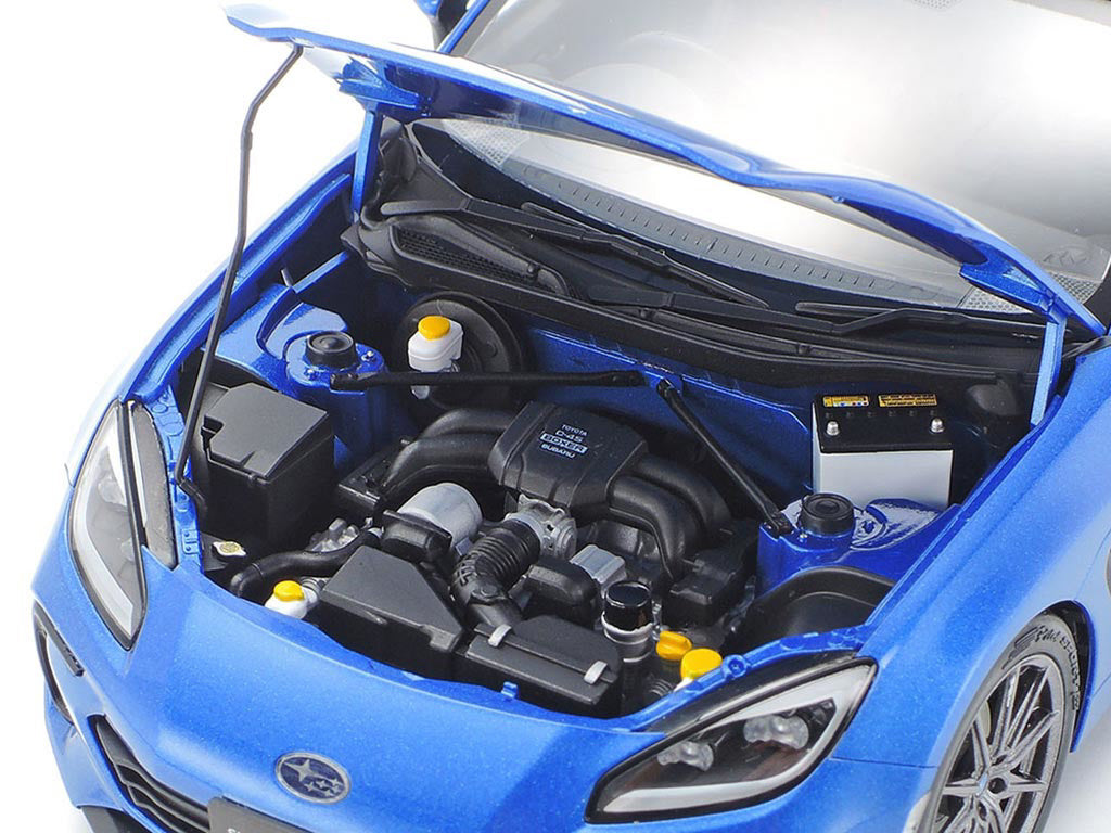 Blue car with open hood showing engine components on a white background