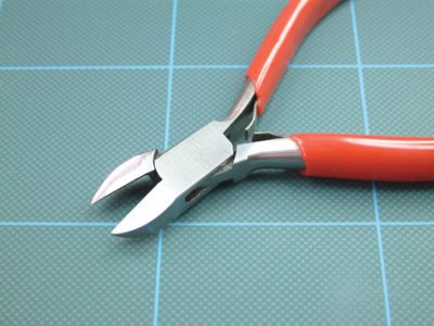 Pair of red-handled wire cutters on a grid background
