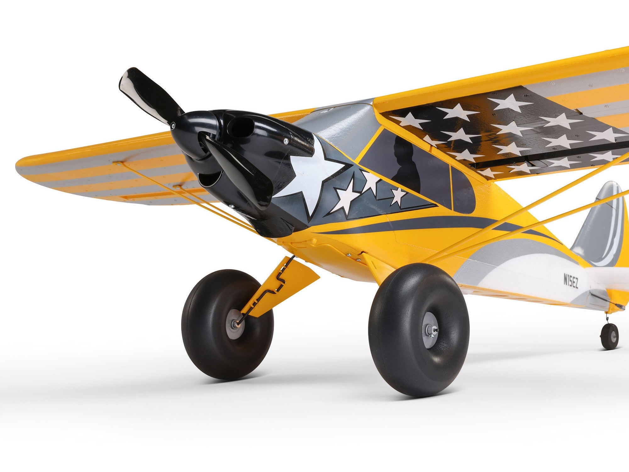Carbon Cub S 2 Cleetus McFarland RC airplane front view with vibrant yellow and star-patterned wings.
