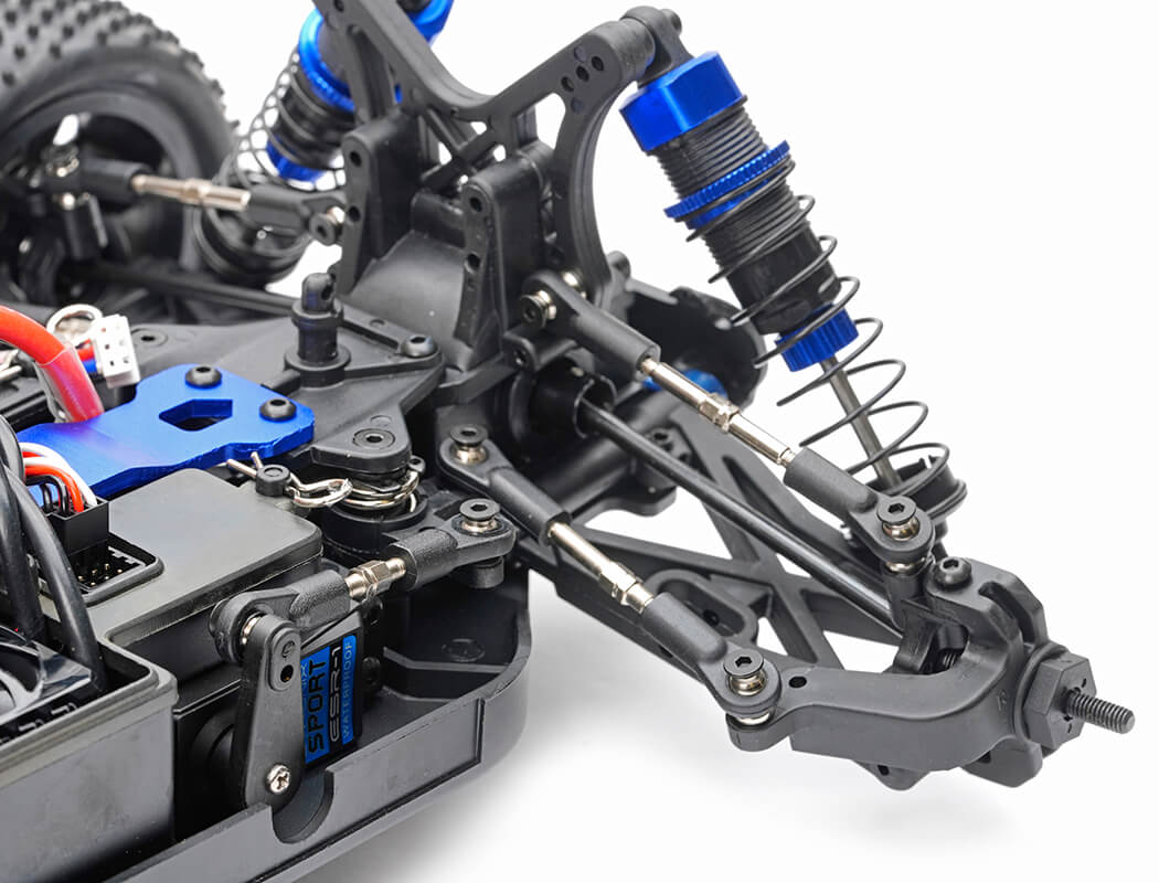 Close-up of an RC car chassis with suspension and steering components on a white background