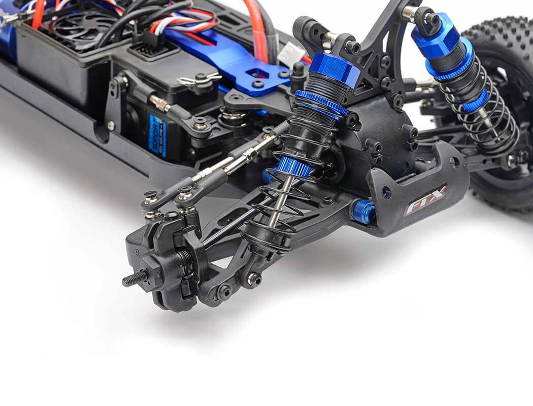 Close-up of a detailed model car chassis with suspension and electronic components on a white background