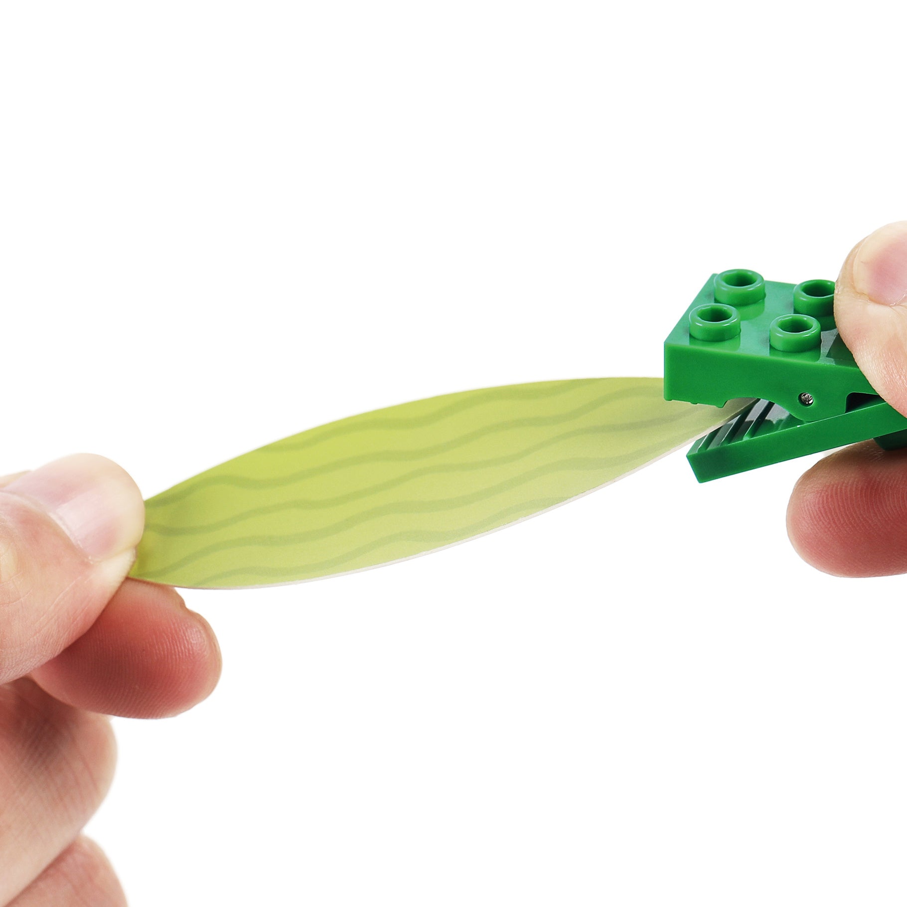 Hand holding a green leaf piece of the CaDA Flower Garden model C71022W, showcasing its realistic design and detail.