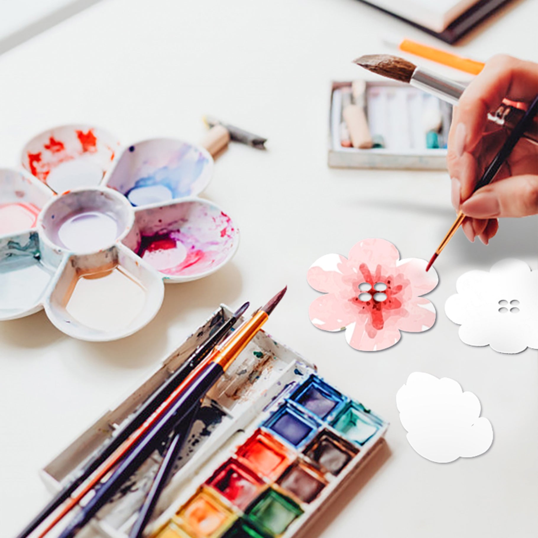 CaDA Flower Garden model creation process with paints and brushes on table.