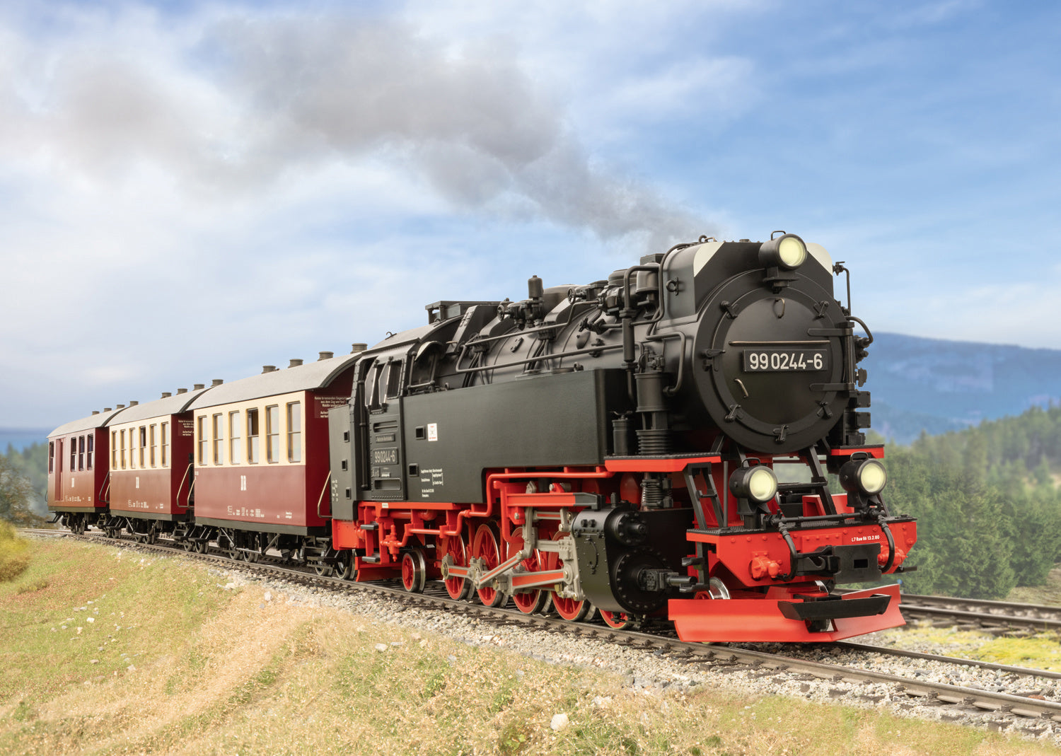 Steam locomotive on a railway track with a scenic background