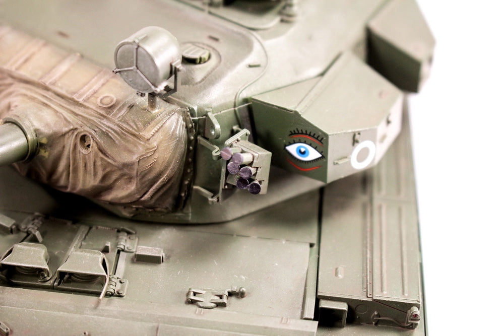 Close-up of a tank with a face painted on it, featuring an eye and a mouth.