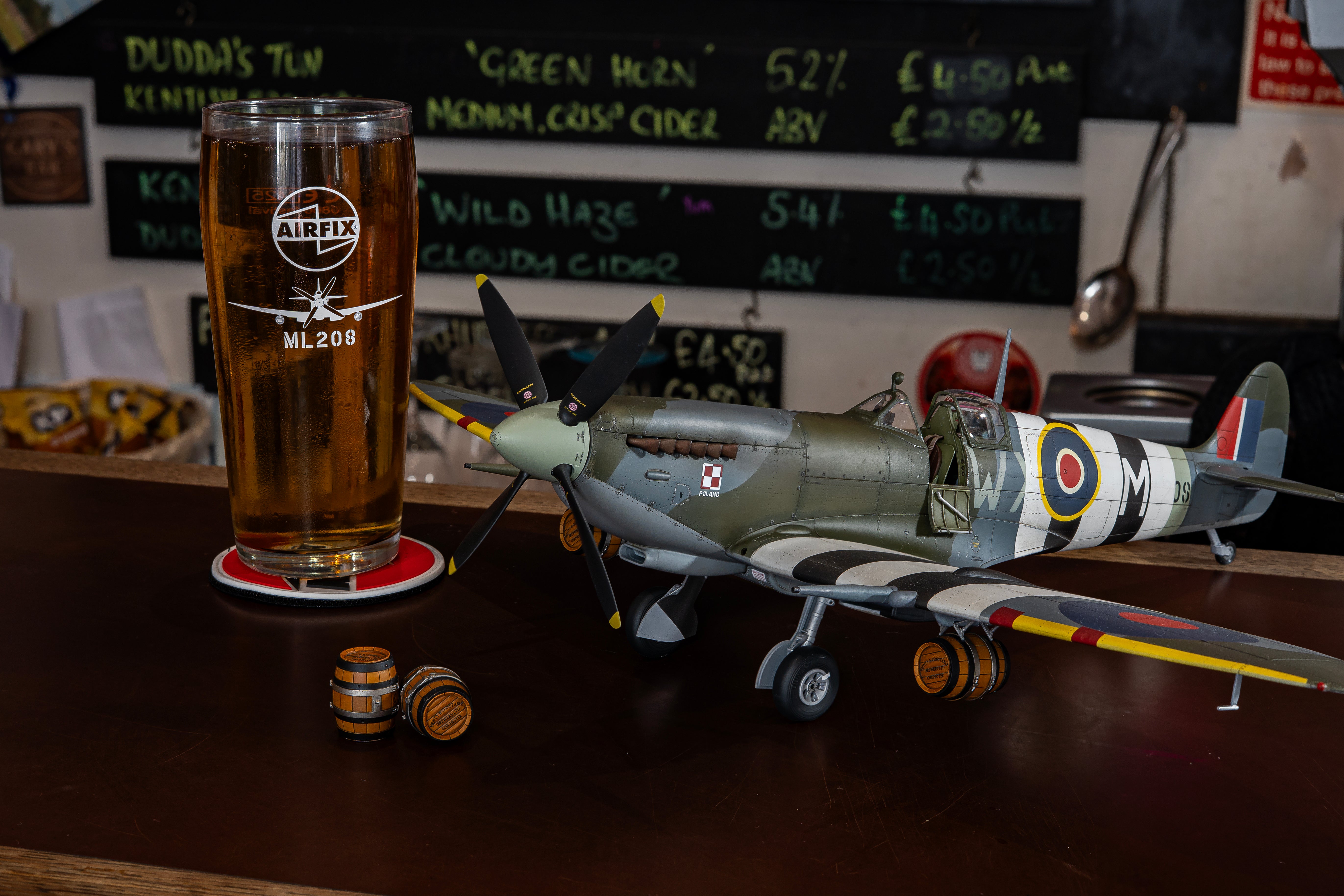 Model airplane on a table with a glass of beer and coasters.