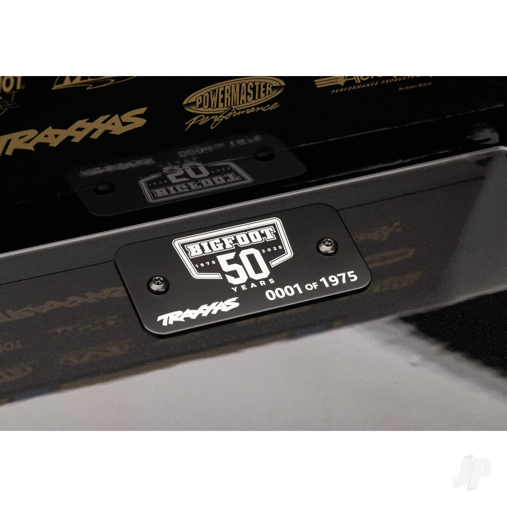 Close-up of a car with a 'Big Foot 50 Years' plaque on a black background.