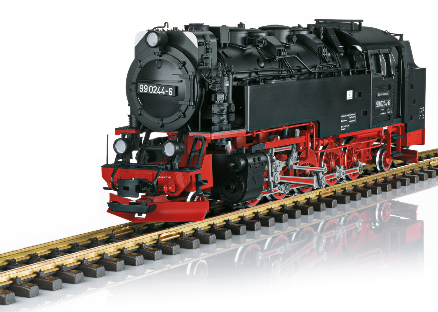 Model steam locomotive on a track with a white background