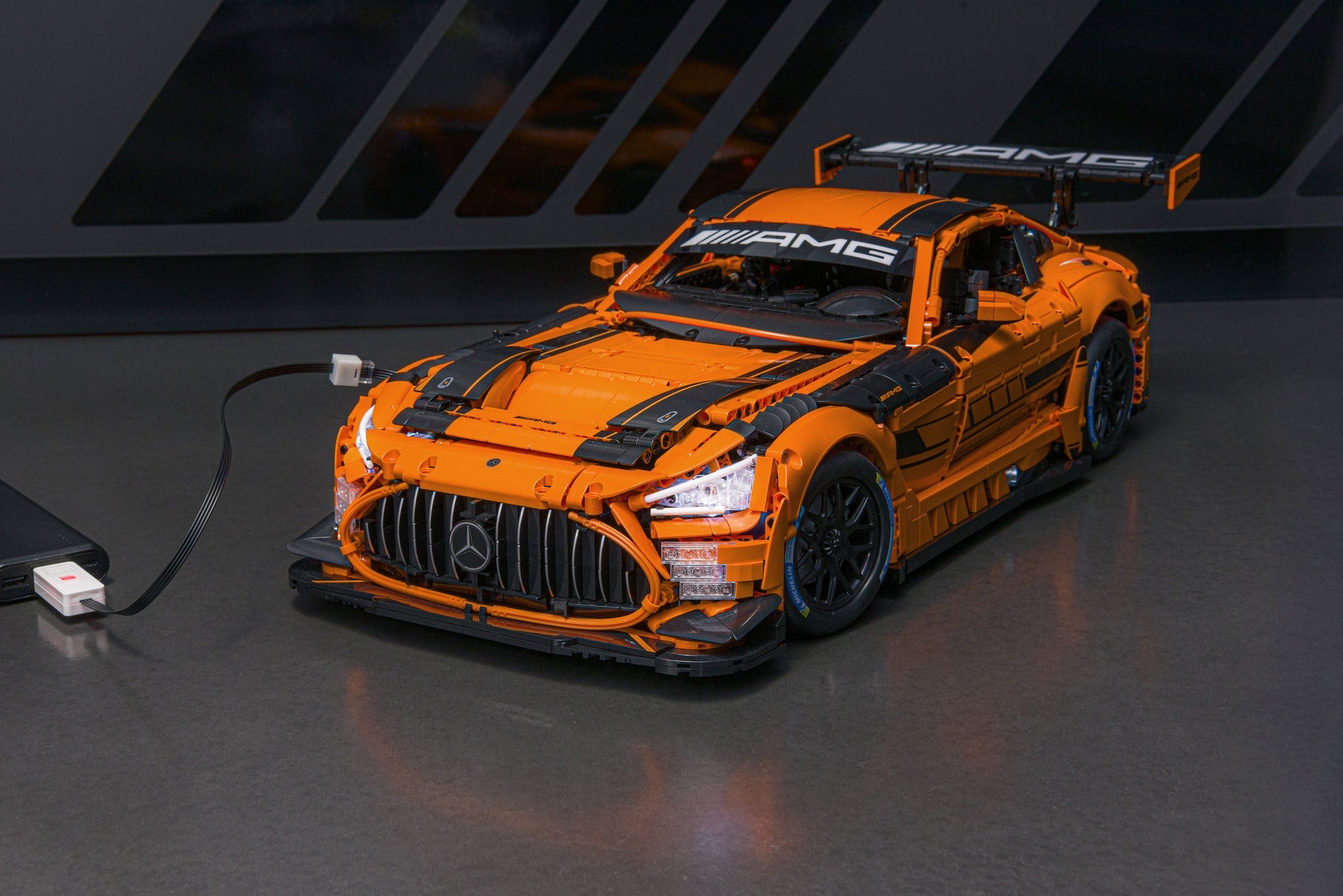 CaDa Mercedes-AMG GT3 model displayed on a grey surface, featuring an orange and black colour scheme.