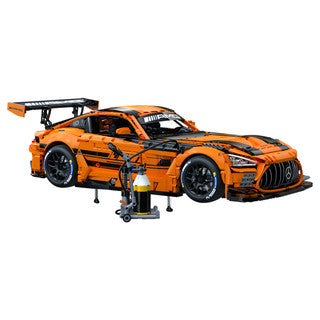 CaDa Mercedes-AMG GT3 model showcasing orange and black design with a detailed workshop tool next to it.